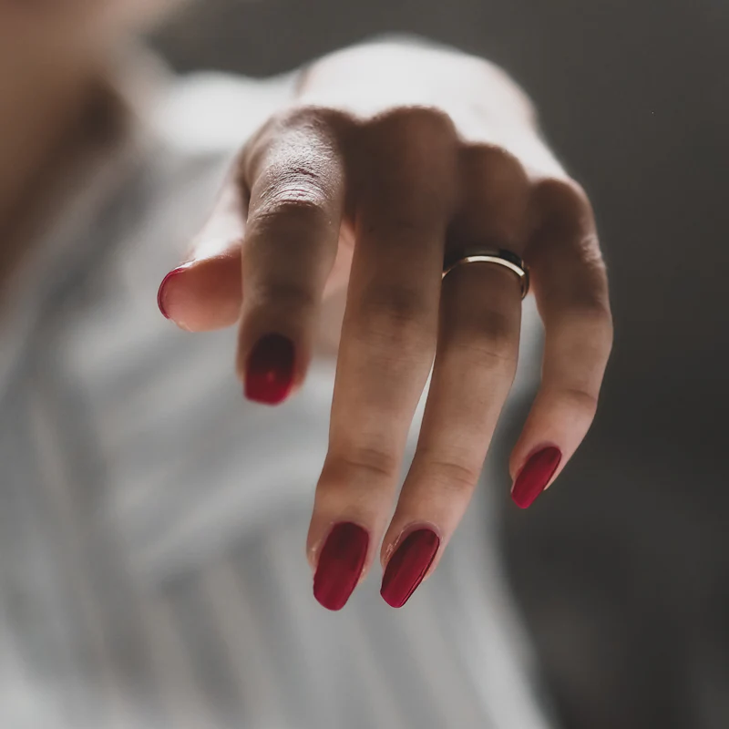 Burgundy oval nails with a thin silver ring