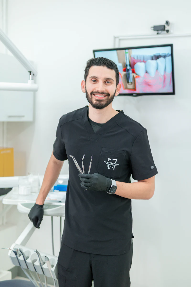 Dr. Sam Whitley in black scrubs, smiling in a treatment room