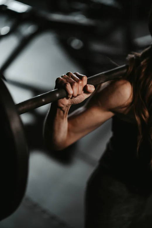 Close-up of a hand gripping a loaded barbell before a squat