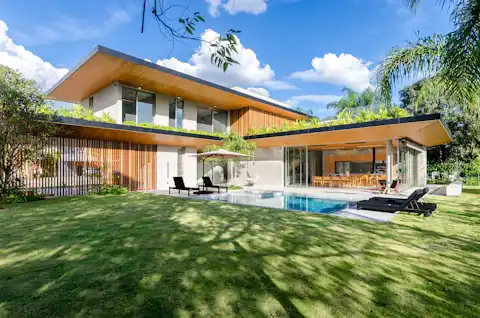 Garden home with lawn, palms and a long pool