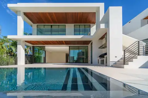 White rendered modern home with timber soffits above an infinity pool