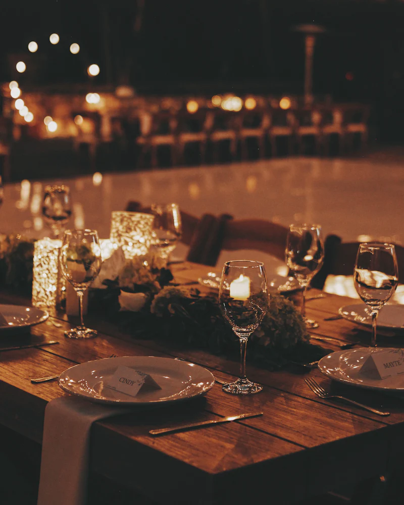 Candlelit tables glowing in a dark dining room